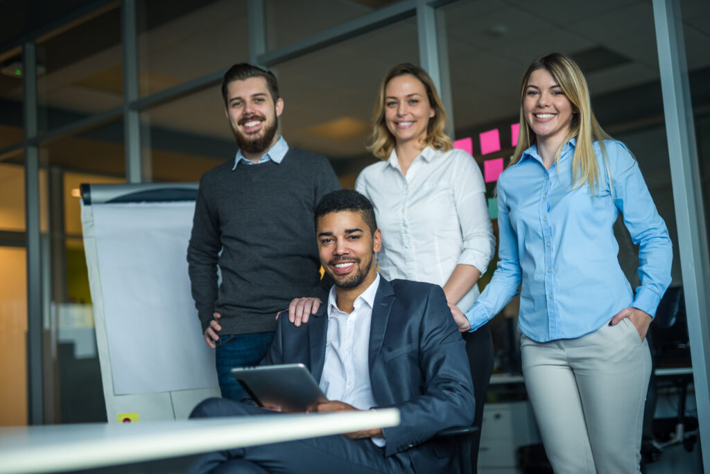 Equipo profesional sonriendo, representando la importancia de la formación y el desarrollo de habilidades en una empresa.